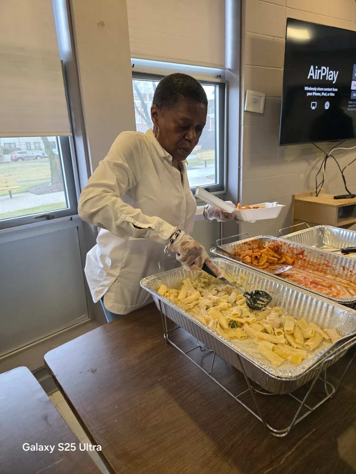 A Student Music Project volunteer serving lunch to a senior resident
