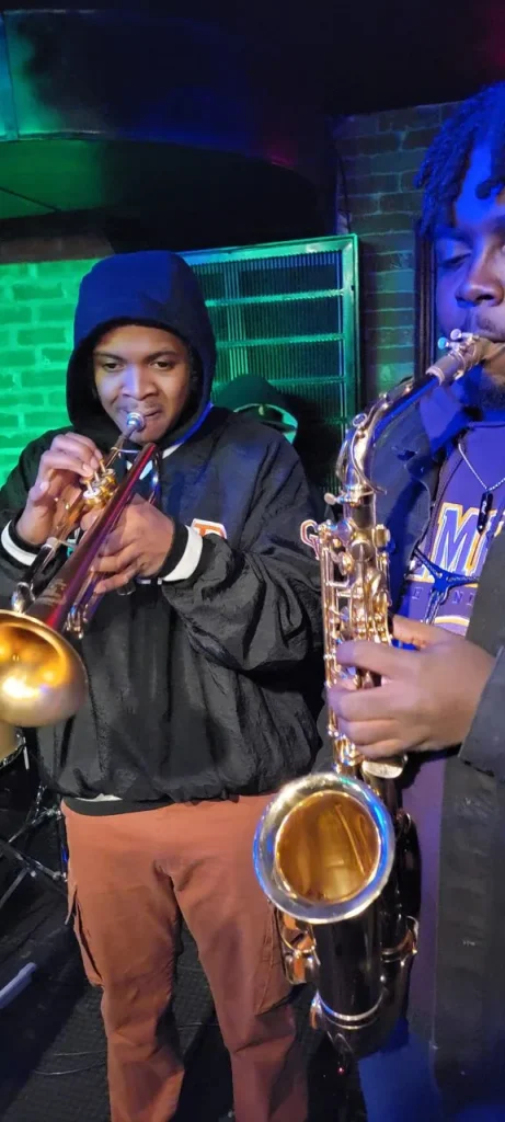 Young musicians perform on trumpet and saxophone