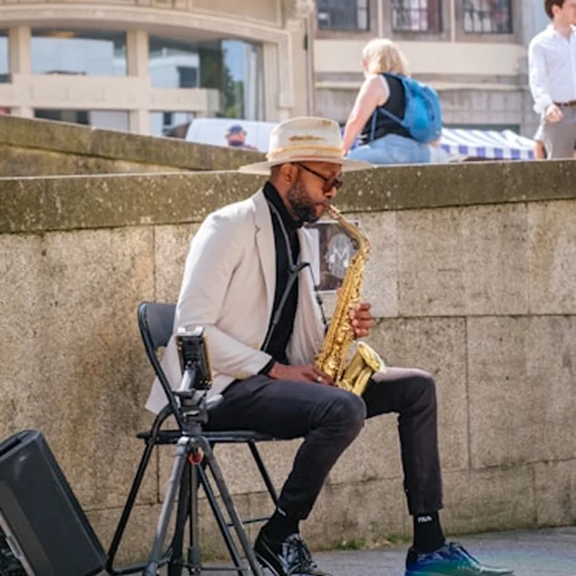 A young saxophonist performs outdoors.